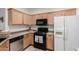 Charming kitchen with light wood cabinets, black appliances and stainless steel dishwasher at 11591 W Jefferson St, Avondale, AZ 85323