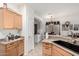 Kitchen featuring light wood cabinetry, black sink, and access to the breakfast nook at 11591 W Jefferson St, Avondale, AZ 85323
