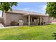 Landscaped backyard with a covered patio, grill, and well-maintained lawn at 1182 E Canyon Way, Chandler, AZ 85249