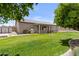 Lush backyard with a covered patio, stainless steel grill, and ample lawn space at 1182 E Canyon Way, Chandler, AZ 85249