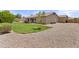 Lush backyard with green lawn, covered patio, desert landscaping, and mature trees at 1182 E Canyon Way, Chandler, AZ 85249