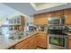 Well-equipped kitchen featuring stainless steel appliances, light wood cabinetry, and ample counter space at 12154 S Ki Rd, Phoenix, AZ 85044