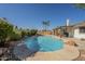 Backyard pool includes covered patio with barbecue, manicured landscaping and rock features at 12154 S Ki Rd, Phoenix, AZ 85044