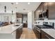 Stylish kitchen with a large island, dark cabinetry, stainless steel appliances, and modern lighting at 12538 E Pivot Peak --, Gold Canyon, AZ 85118