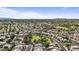 Overhead view of a suburban community featuring tree-lined streets and houses amidst open spaces and manicured greenery at 1413 E San Remo Ave, Gilbert, AZ 85234