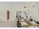 Elegant dining room with vaulted ceilings, contemporary chandelier, and view into the living area at 1413 E San Remo Ave, Gilbert, AZ 85234