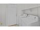 Clean laundry room with a white washer and dryer, convenient overhead storage, and tile flooring at 1413 E San Remo Ave, Gilbert, AZ 85234