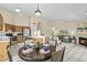 Open-concept living and dining area with tile floors, a fireplace, and oak kitchen cabinets at 1413 E San Remo Ave, Gilbert, AZ 85234