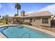 Inviting backyard pool with Baja shelf, lush landscaping, and covered patio at 1413 E San Remo Ave, Gilbert, AZ 85234