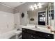 Bathroom featuring a white vanity and tub and a large mirror reflecting the bedroom at 14228 W Weldon Ave, Goodyear, AZ 85395
