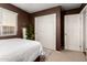 A bedroom with white walls, white trim, and large double closets at 14228 W Weldon Ave, Goodyear, AZ 85395