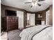 A bedroom featuring dark brown walls, a dresser with a TV, and plush gray rug at 14228 W Weldon Ave, Goodyear, AZ 85395