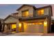 Inviting house with a well-lit garage and tastefully designed exterior features at 14228 W Weldon Ave, Goodyear, AZ 85395