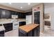 Functional kitchen features a central island, white appliances, and dark cabinetry at 14228 W Weldon Ave, Goodyear, AZ 85395
