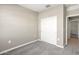Neutral-colored bedroom featuring carpet, a closet, and an open doorway to the hallway at 1423 S 239Th Dr, Buckeye, AZ 85326