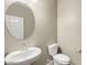 Stylish half-bathroom featuring a pedestal sink, modern fixtures, and a toilet at 1423 S 239Th Dr, Buckeye, AZ 85326