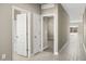 Neutral hallway with tile flooring and white doors leading to various rooms at 1423 S 239Th Dr, Buckeye, AZ 85326