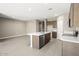 Modern kitchen with stainless steel appliances and island with tile flooring at 1423 S 239Th Dr, Buckeye, AZ 85326