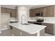 Modern kitchen featuring a large center island with a stainless steel sink and faucet at 1423 S 239Th Dr, Buckeye, AZ 85326