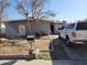 Modest grey brick home showing the front yard with sparse landscaping, a mailbox and a white pickup truck in the driveway at 14627 N 33Rd Ave, Phoenix, AZ 85053