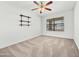 Bright bedroom features a ceiling fan, dark wood shelving and large window at 17210 N Cassi Dr, Surprise, AZ 85374