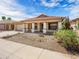Single story home features tile roof, covered porch, xeriscaped front yard, and low-maintenance landscaping at 17210 N Cassi Dr, Surprise, AZ 85374