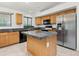 Updated kitchen features wood cabinets, stone countertops, stainless steel refrigerator and kitchen island at 17210 N Cassi Dr, Surprise, AZ 85374