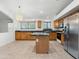 Bright kitchen boasts wood cabinets, stone countertops, and stainless steel refrigerator at 17210 N Cassi Dr, Surprise, AZ 85374