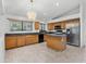 Well-lit kitchen featuring tile flooring, wood cabinets, an island, and stainless-steel appliances at 17210 N Cassi Dr, Surprise, AZ 85374