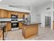 Spacious kitchen featuring an island, tile flooring, wood cabinets, and stainless-steel appliances at 17210 N Cassi Dr, Surprise, AZ 85374