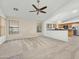 Open living room features windows, neutral carpeting and flows into the kitchen at 17210 N Cassi Dr, Surprise, AZ 85374