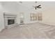 Open living room features a fireplace, neutral carpeting, and large windows at 17210 N Cassi Dr, Surprise, AZ 85374