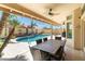 Inviting covered patio featuring a dining table, ceiling fans, and views of the pool and backyard at 18907 N 92Nd Way, Scottsdale, AZ 85255