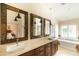 Luxurious bathroom with dual sinks, framed mirrors, soaking tub, and plantation shutters for natural light at 18907 N 92Nd Way, Scottsdale, AZ 85255