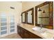Bathroom featuring double sinks, custom mirrors, walk-in shower, and frosted glass doors at 18907 N 92Nd Way, Scottsdale, AZ 85255