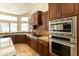 Close up of kitchen featuring dark wood cabinetry, granite countertops, and stainless steel appliances at 18907 N 92Nd Way, Scottsdale, AZ 85255