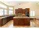 A kitchen featuring dark wood cabinetry, granite countertops, and a central island with seating at 18907 N 92Nd Way, Scottsdale, AZ 85255