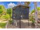 Backyard aviary structure with dark screening and mature landscaping at 1907 E Huber St, Mesa, AZ 85203