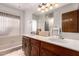Bathroom featuring dual sinks, wood cabinets, tiled flooring and shower/tub combo at 1907 E Huber St, Mesa, AZ 85203