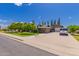 Single-story home with a well-maintained lawn, mature trees, and a basketball hoop on a large driveway at 1907 E Huber St, Mesa, AZ 85203