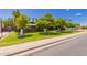 Inviting single-story home featuring a lush, green lawn and vibrant citrus trees, adding natural beauty at 1907 E Huber St, Mesa, AZ 85203