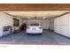 Well-lit garage featuring a white car, storage cabinets, and epoxy floors at 1907 E Huber St, Mesa, AZ 85203
