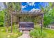 Backyard hot tub with wooden trellis covering and mature landscaping at 1907 E Huber St, Mesa, AZ 85203