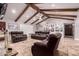 Spacious living room featuring vaulted ceilings with wooden beams, stone floors, and a cozy seating arrangement at 1907 E Huber St, Mesa, AZ 85203