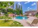Inviting backyard pool area with mature landscaping, lounge chairs and stone pavers at 1907 E Huber St, Mesa, AZ 85203