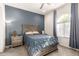Cozy bedroom features a large window, ceiling fan, and stylish furniture with a blue accent wall at 19215 N 259Th Ave, Buckeye, AZ 85396