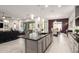 An open concept kitchen with a dark countertop island, stainless steel appliances, and a view of the living and dining areas at 19215 N 259Th Ave, Buckeye, AZ 85396