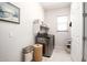 Well-lit laundry room with modern washer and dryer, storage shelves, and convenient access to the house at 19215 N 259Th Ave, Buckeye, AZ 85396