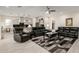 Spacious living room with stylish rug, ceiling fan and comfortable black leather seating at 19215 N 259Th Ave, Buckeye, AZ 85396