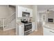 Modern kitchen features stainless steel appliances, white cabinets, and view into the living room at 1961 N Hartford St # 1087, Chandler, AZ 85225